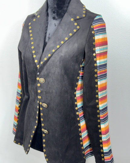 Black fabric with colorful striped border and gold- brass toned buttons on a soft fabric background