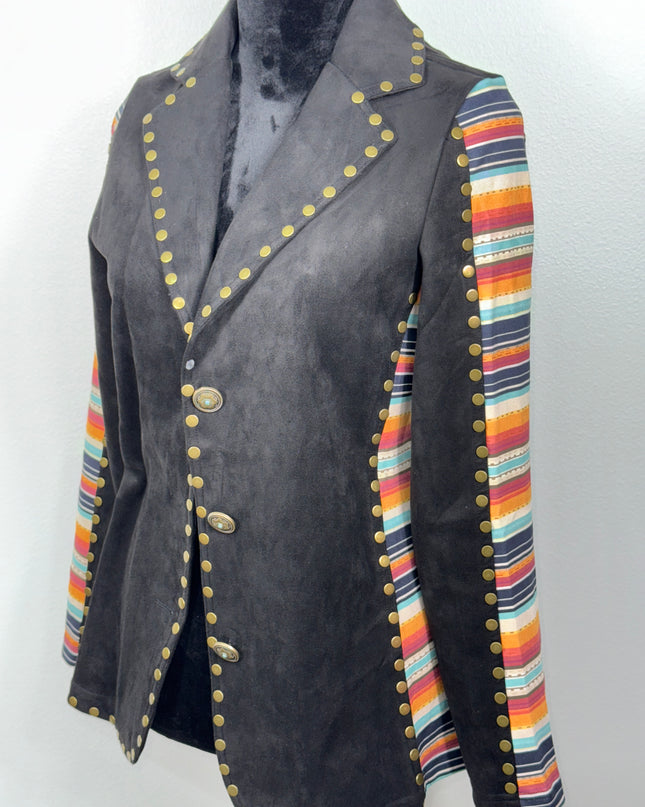 Black fabric with colorful striped border and gold- brass toned buttons on a soft fabric background